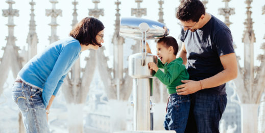 Francesca Fedeli, Roberto D'Angelo and their son Mario in front of a fountain, playing and smiling
