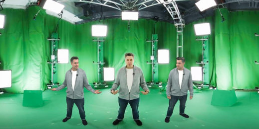 man stands in front of a green screen