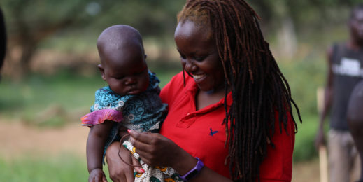 Reporter Verah Okeyo holds a baby on her visit to West Pokot County in Kenya