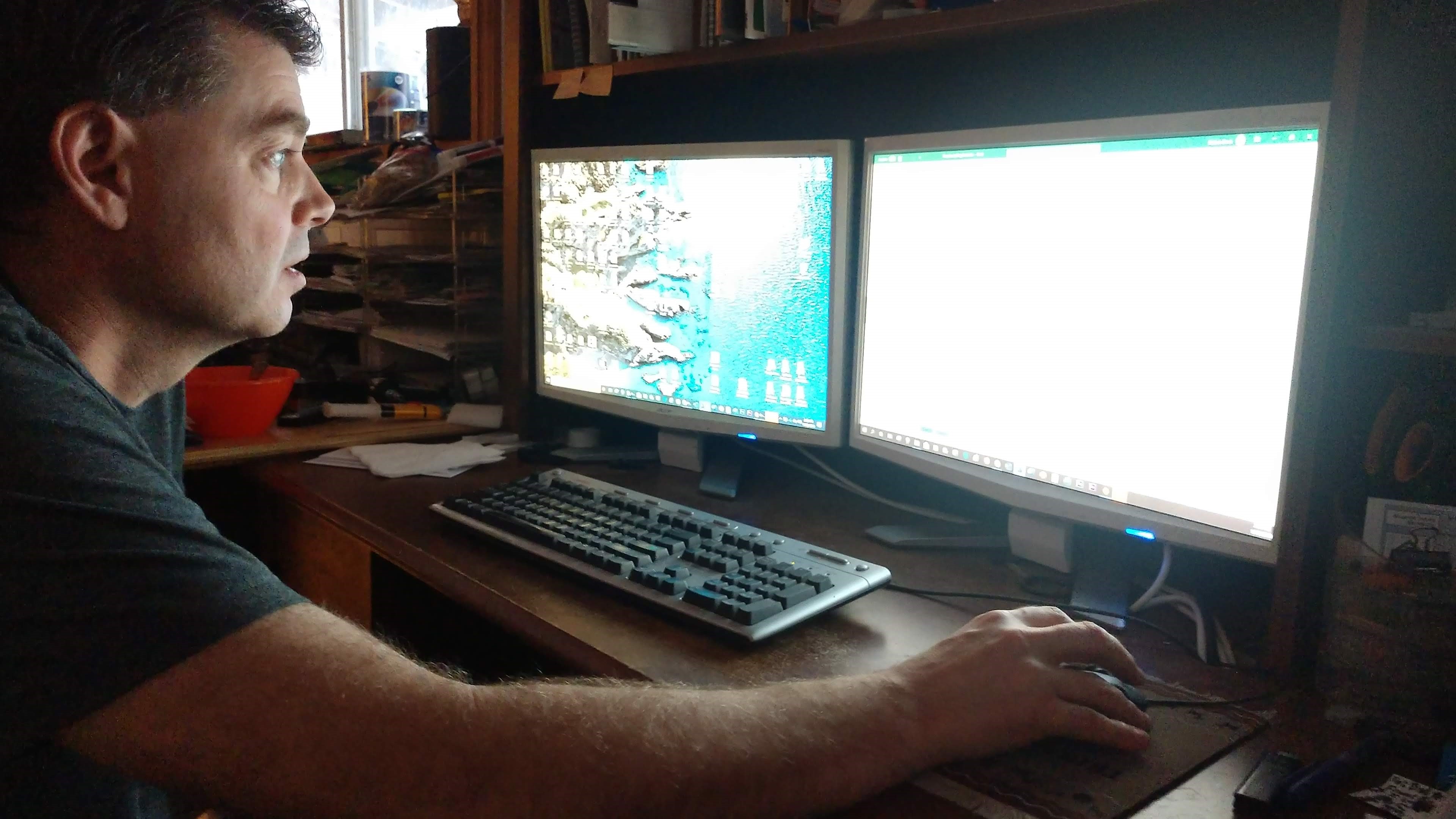 Man looks at what's on his dual monitor computer setup