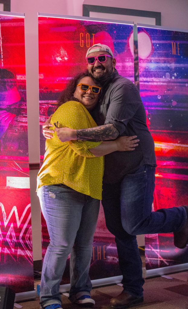Photo of siblings Janice and Jayson Rivera standing in front of a virtual reality game during the pre-show event before rock band Muse's concert Feb. 22, 2019 in Houston, Texas.