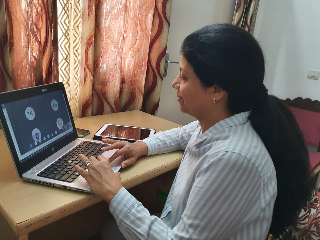 A woman works on a laptop in her home