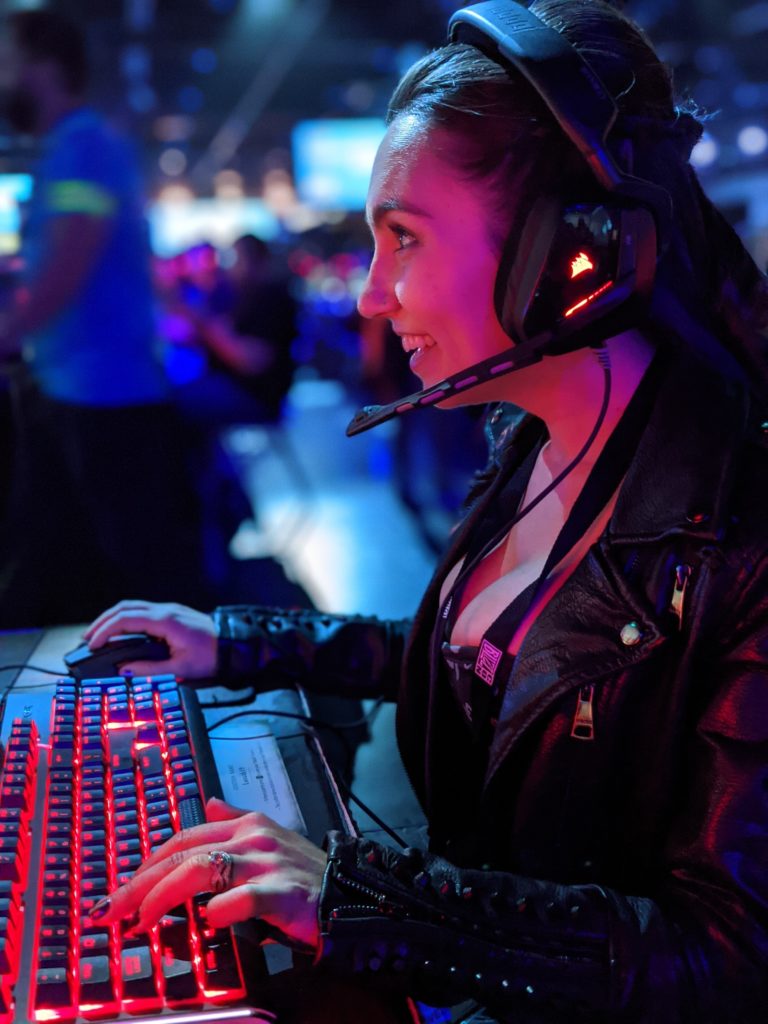 Trisha Hershberger with headset on, gaming on a keyboard, side profile