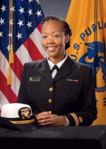 Woman in a military uniform in front of the U.S. flag