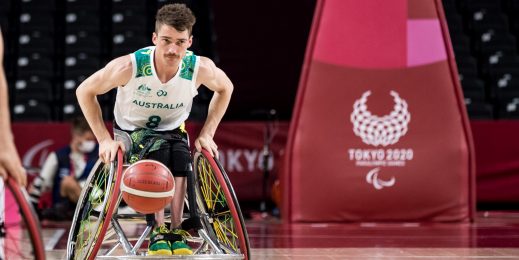 Man in wheelchair playing basketball at Kim Robins at Paralympics