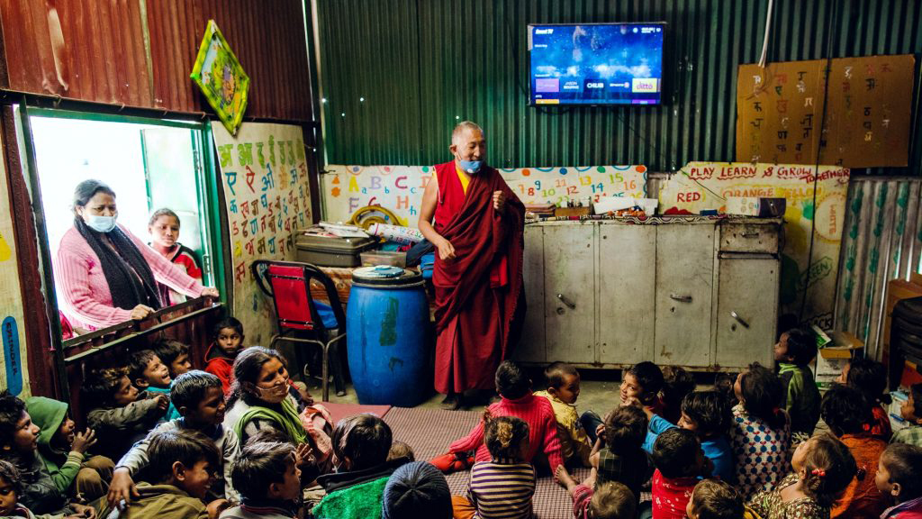 Man teaching a class of kids in rural India