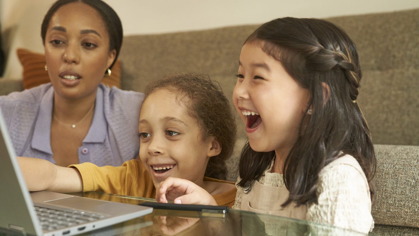 Woman and two girls enjoying what's on their laptop computer