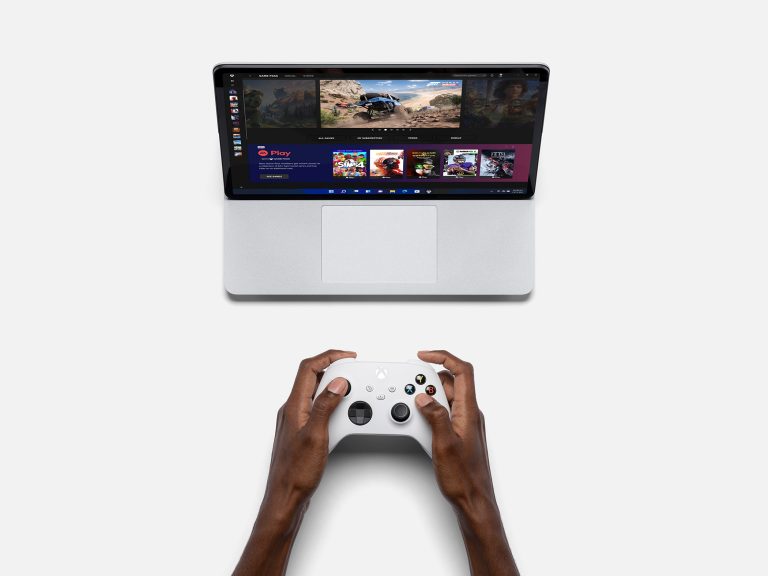 A person playing a game on a Surface laptop using a Xbox controller