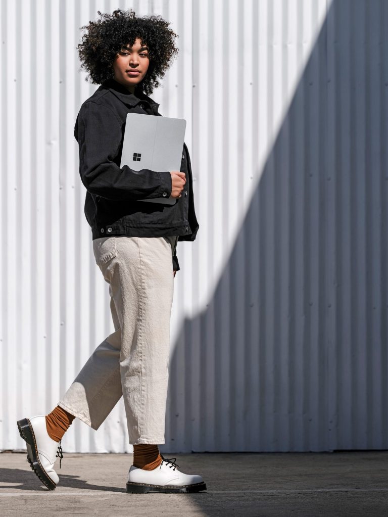 A woman holds a Surface laptop