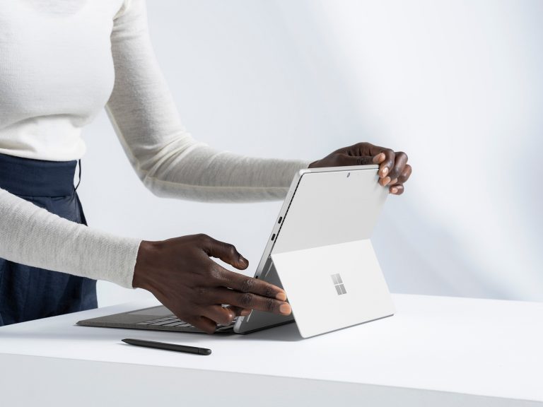 A person opening a Surface Pro 8