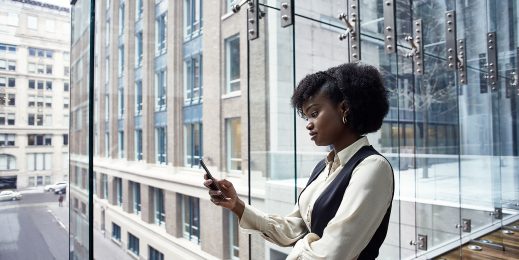 Woman in an office building looking at her phone