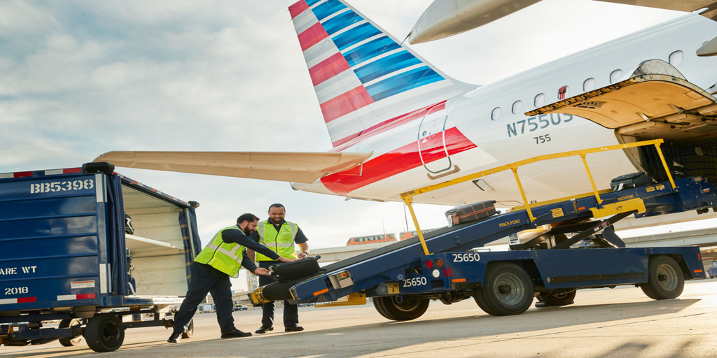 American Airlines employees load luggage onto an airplane