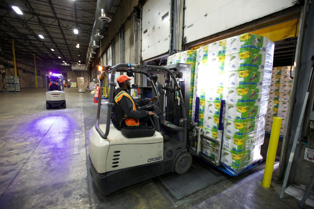 Fork lift driver moves a pallet of Bounty paper towels in a warehouse