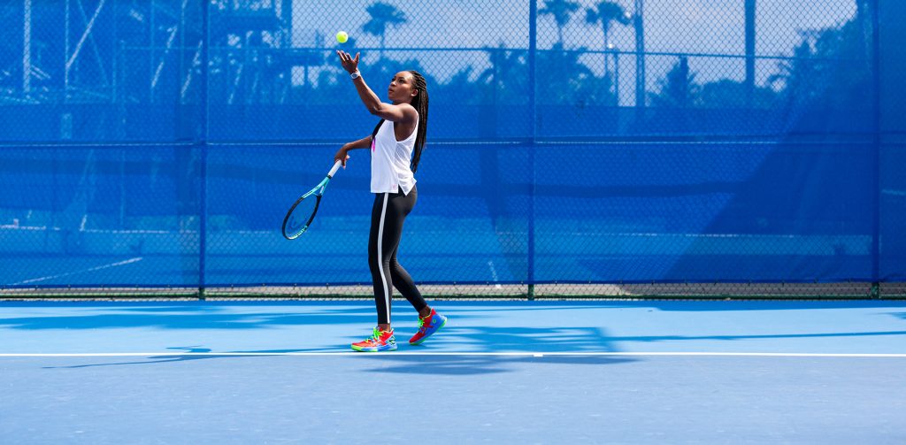 Woman throws a tennis ball in air