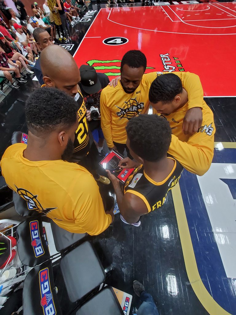 Basketball players huddle around a tablet