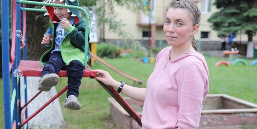 Woman stands with son at the playground