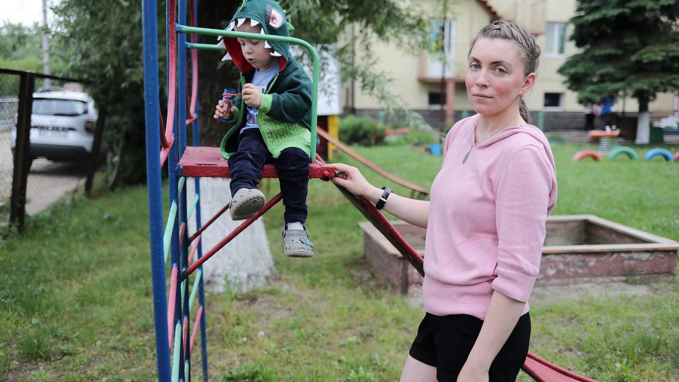 Woman stands with son at the playground