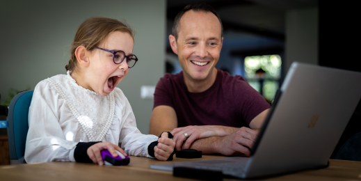 Father and daughter use laptop