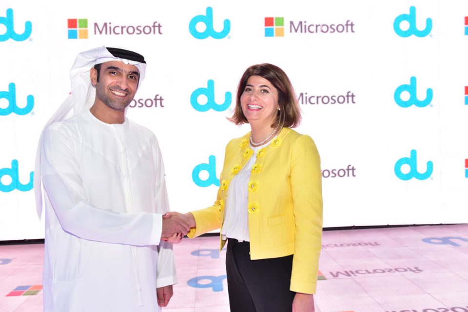 A man and woman shake hands to announce partnership between both companies