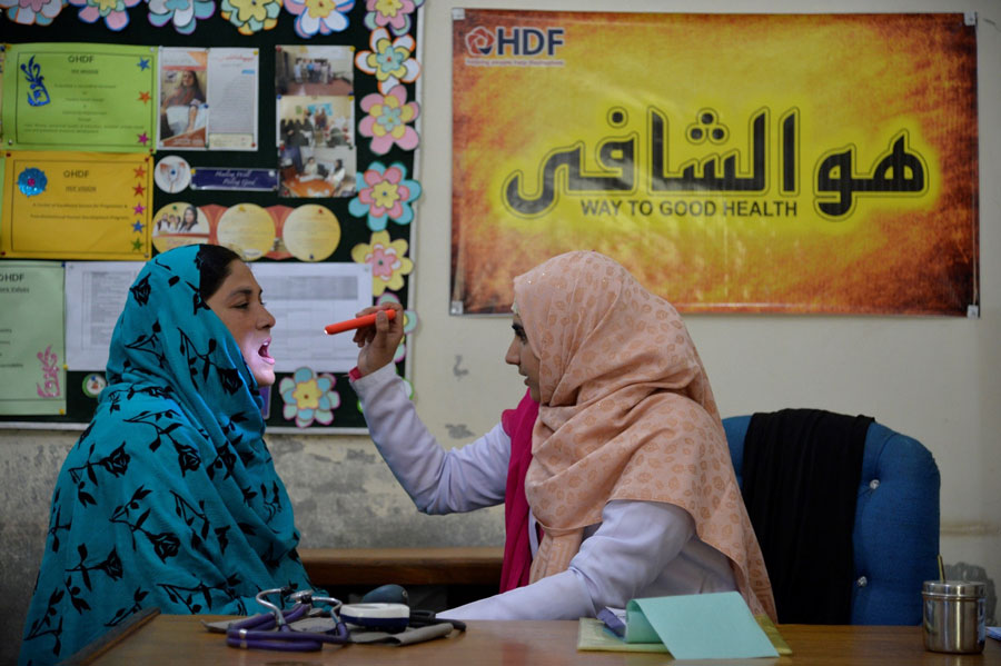 Female doctor wearing hijab examining patient