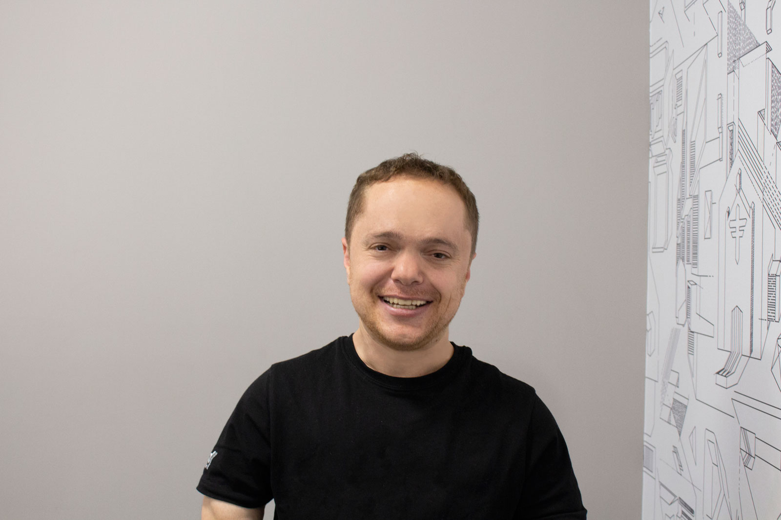 Headshot of man in black t-shirt, smiling 