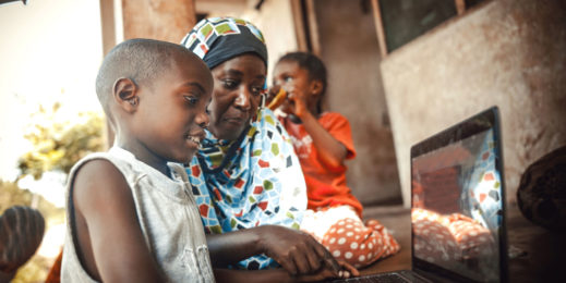 African child and grandmother working together on a laptop