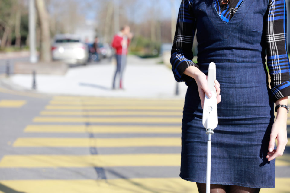 A woman uses WeWalk in the street