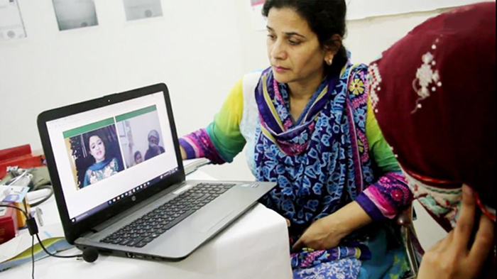 two pakistani looking at a laptop