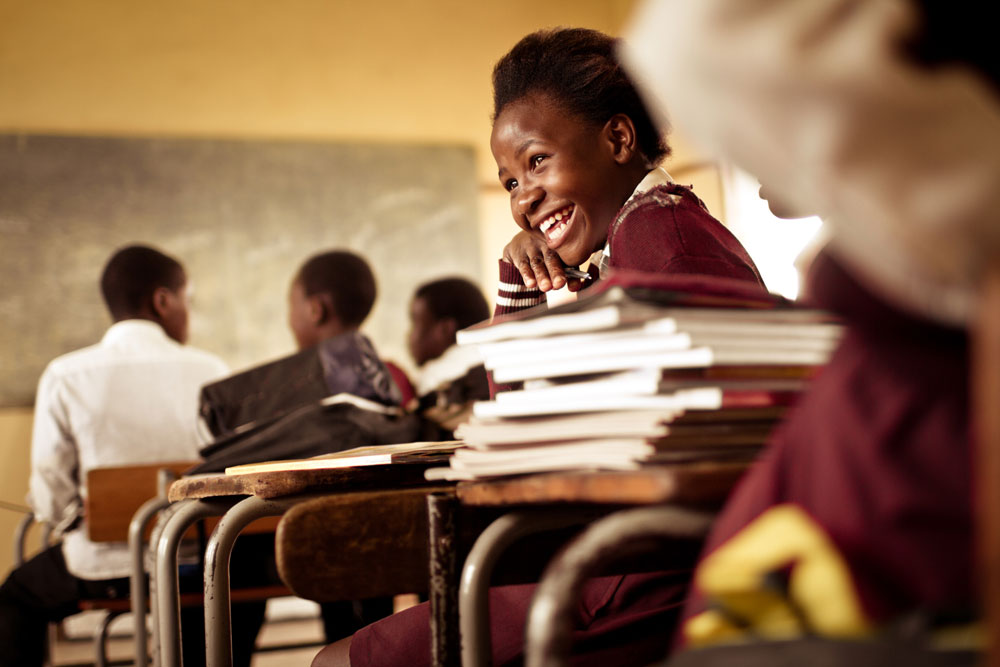 South African school girl smiles and laughs with her classmates