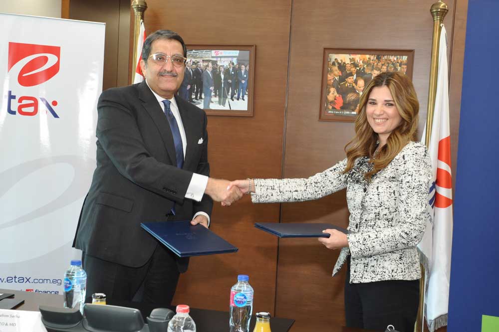 A picture of Mirna Arif and Ibrahim Sarhan shaking hands after signing the agreemen