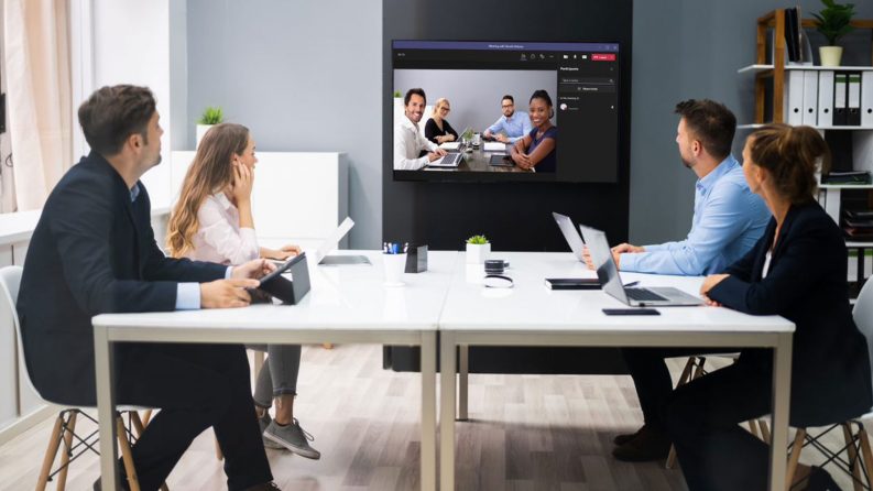 A hybrid work meeting between colleagues online and colleagues in office