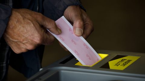 a ballot being inserted into a machine