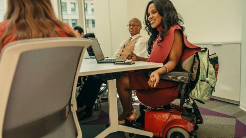 Woman in motorized chair in a meeting