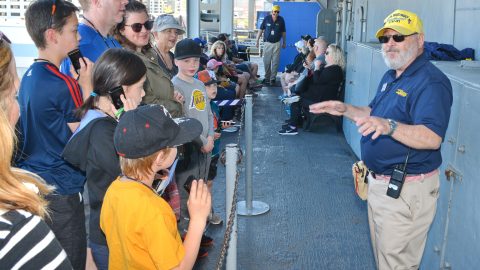 A volunteer talks to visitors on the USS Midway, a floating museum in San Diego, Calif. Photograph: The Midway Museum