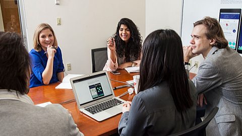 Small group of people talk at a conference table