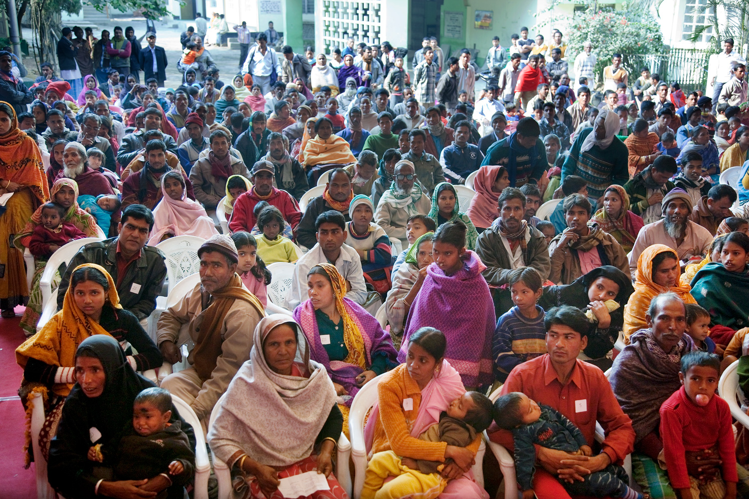 Large crowd of families waiting in a room in India