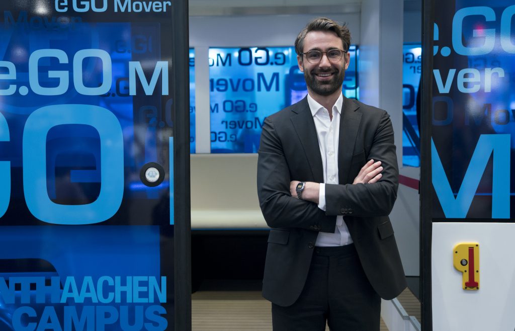 Casimir Ortlieb, CEO and co-founder of e.GO Digital, stands in front of an e.GO Mover.