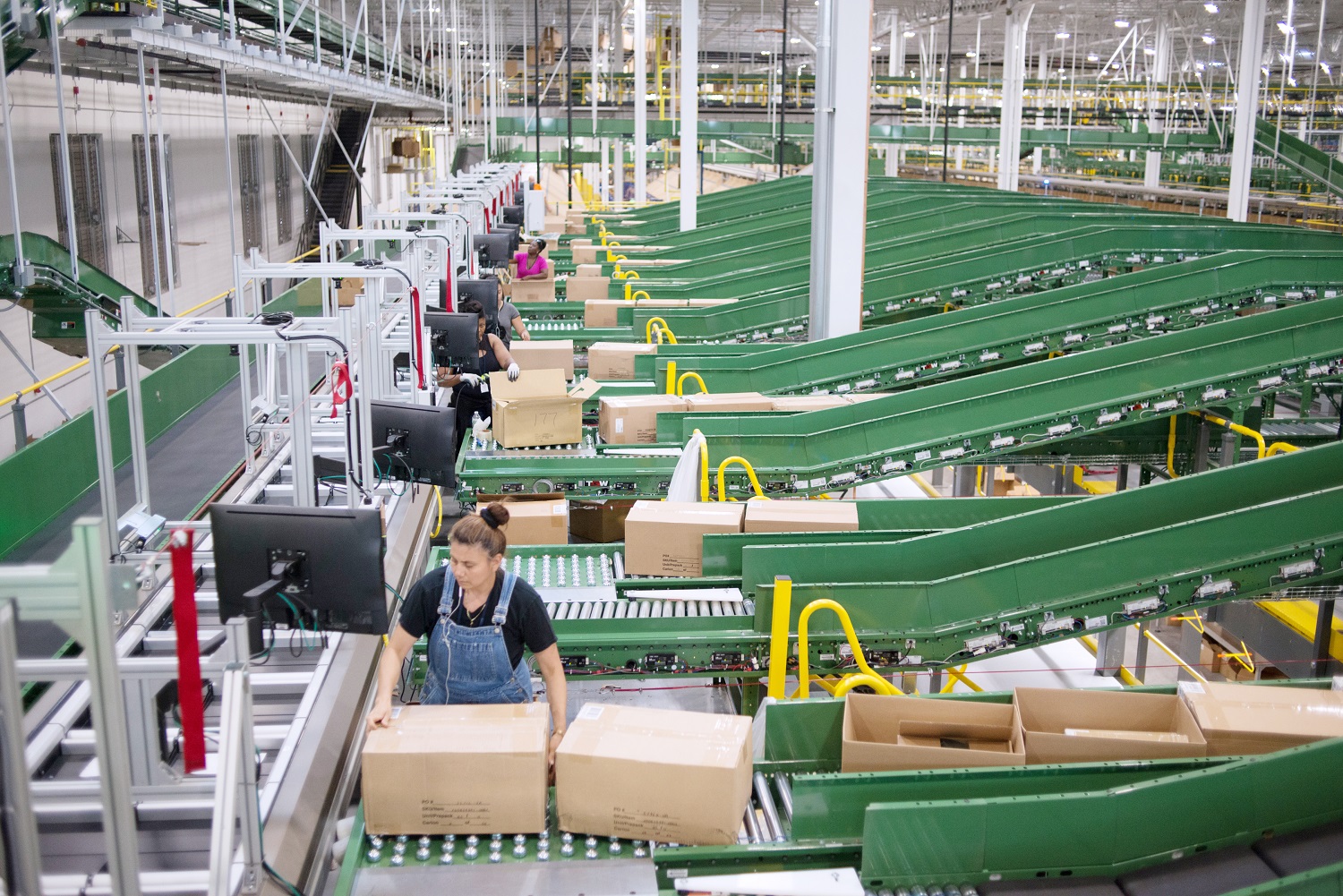 People process packages in a large distribution center