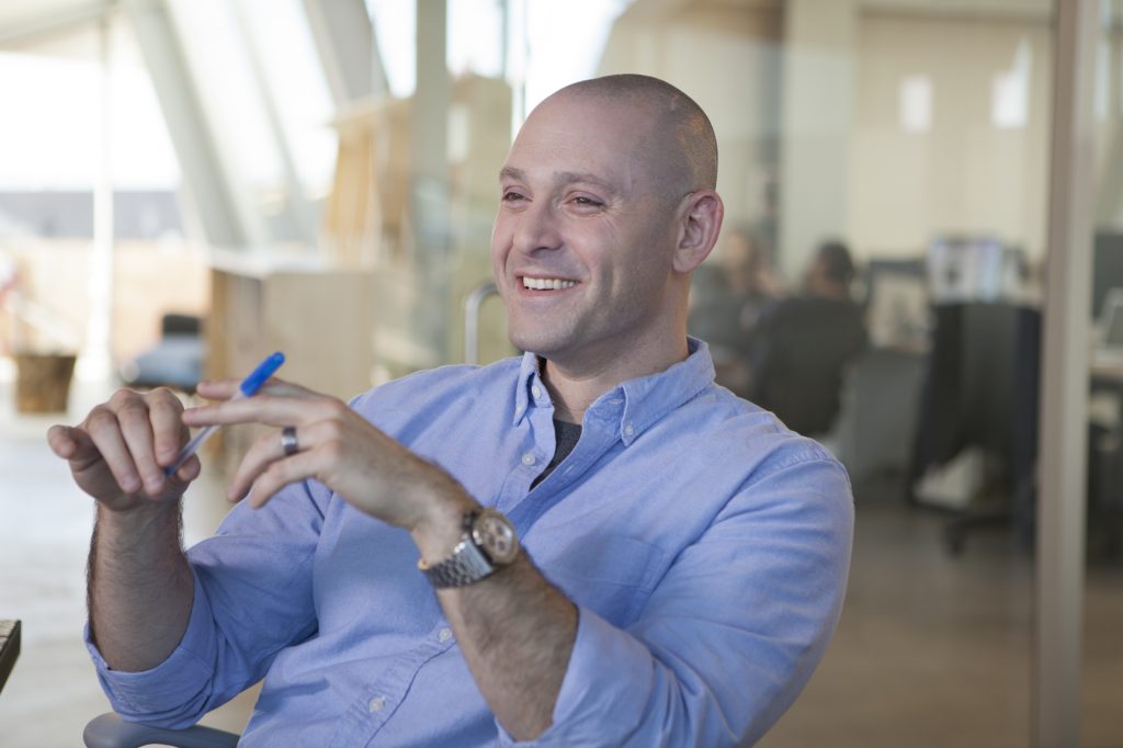 Microsoft's Ben Rudolph sits and smiles at work. 
