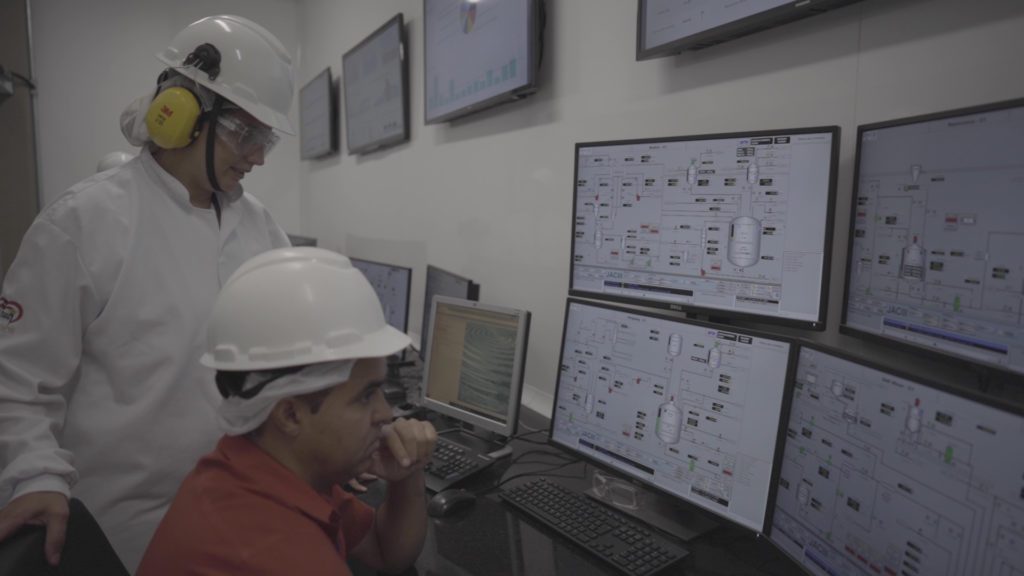 Unilever factory workers view dashboards on a variety of computer screens.