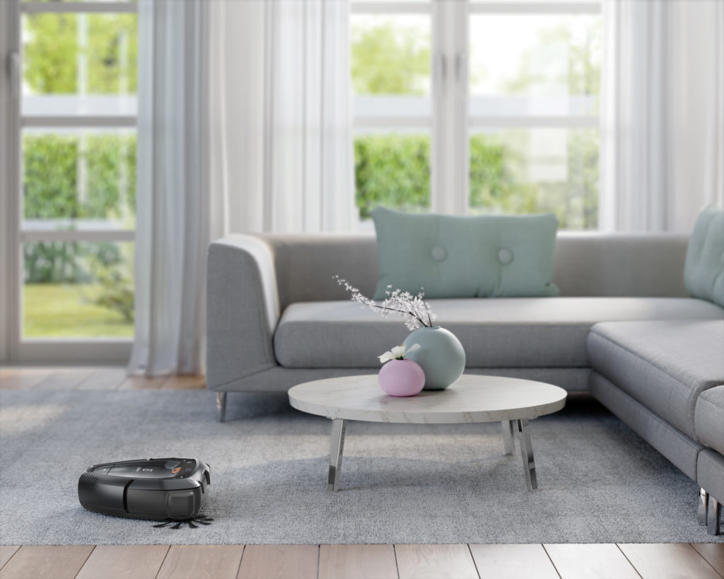 A Pure i9, a cloud-connected robot vacuum. cleans a rug and flooring while navigating a table and sofa.