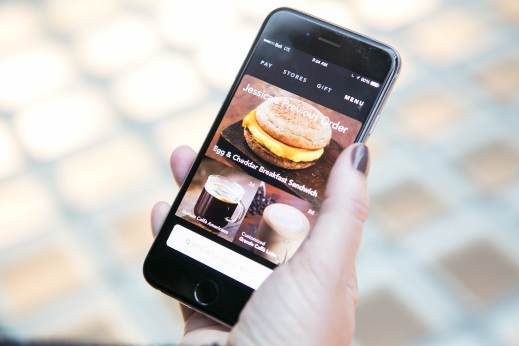 A smart phone displays personalized recommendations to customers via a mobile app.