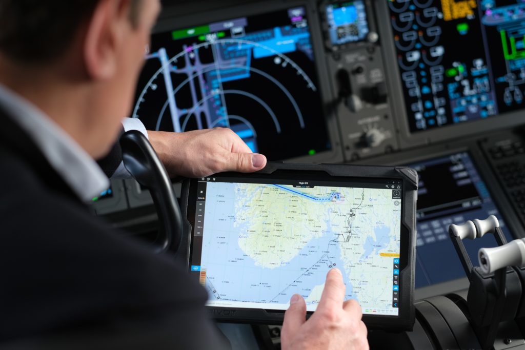 A Norwegian Air Shuttle pilot views a map on a digital device.