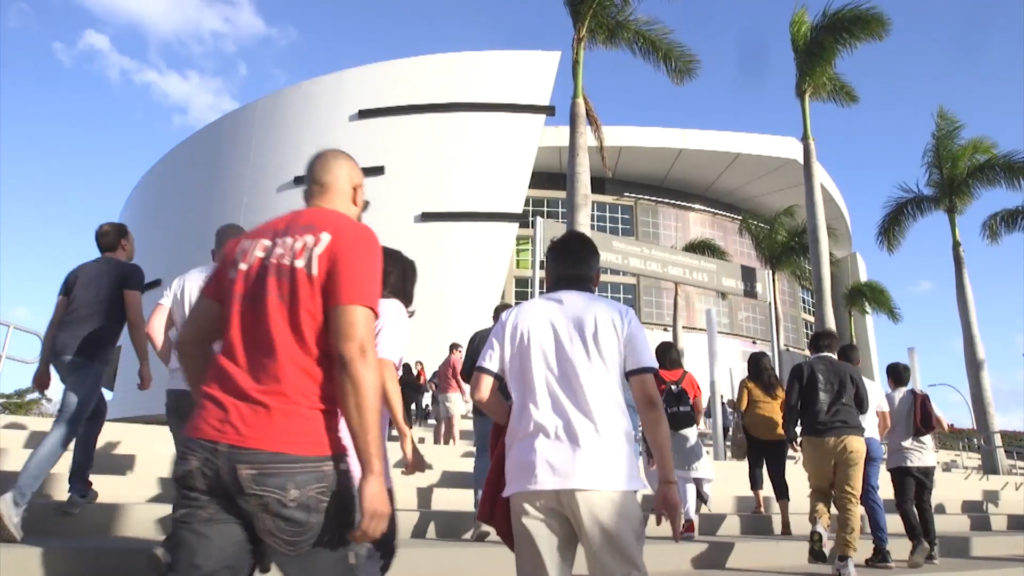 Fans walk into AmericanAirlines Arena in Miami to attend a Miami Heat game.