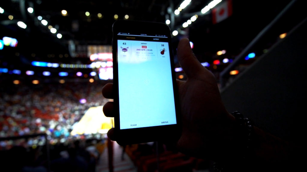 A Miami Heat fan entering AmericanAirlines Arena's seating area shows a smart phone screen showing a digital ticket.