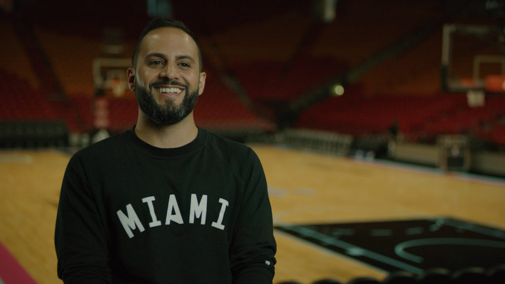 Matthew Jafarian, Heat executive, sits inside an empty AmericanAirlines Arena, smiling. executive vice president of business strategy f