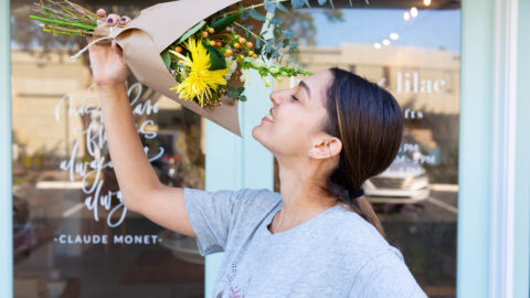 Flower shop owner Melanie Fernandez breathes in the scent of a bouquet of flowers.