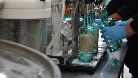 An employee at Silent Pool distillery refills gin bottles