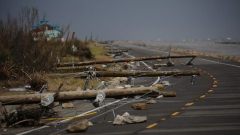 Photo of damaged electricity poles lying across a road in Louisiana after Hurricane Laura in 2020.