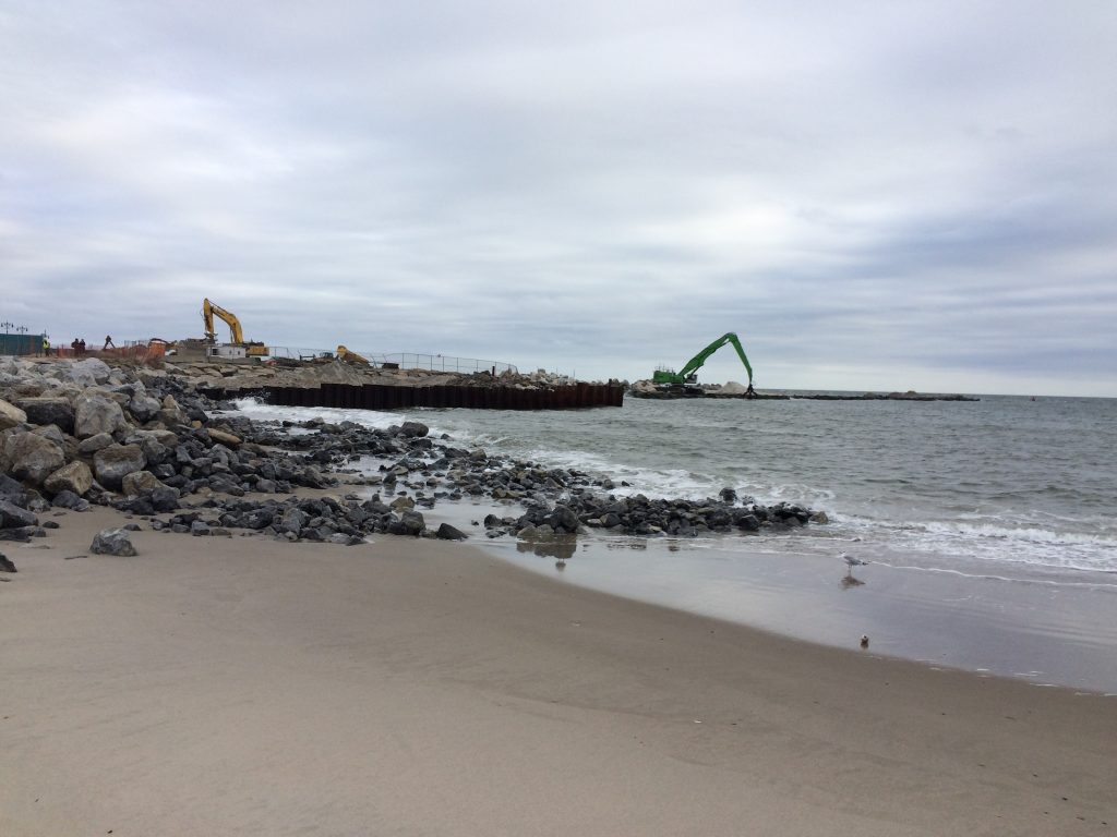 Photo of beach and dune restoration work following Hurricane Sandy showing a beach with machinery in the background.